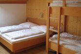 Raum mit Doppelbett und Stockbett